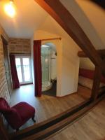 a living room with a red chair and a mirror at 2 chambres privées au calme à la Maison des Bambous in Dijon