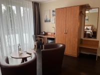 a hotel room with a table and chairs and a desk at Hotel Jellentrup in Münster