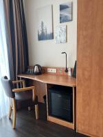 a desk with a television and a chair in a room at Hotel Jellentrup in Münster