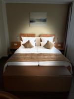 a bedroom with a large bed with white sheets and pillows at Hotel Jellentrup in Münster