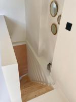a white staircase with a wooden floor in a room at Appartement duplex in Le Touquet-Paris-Plage