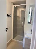 a shower with a glass door next to a sink at Appartement duplex in Le Touquet-Paris-Plage