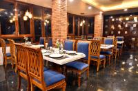 een restaurant met een lange tafel met blauwe stoelen bij Rufina Pinasa Residency in Gangtok