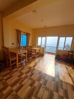 ein Esszimmer mit Tisch und Stühlen und Fenstern in der Unterkunft Himalayan Hidden Treasure in Pokhara