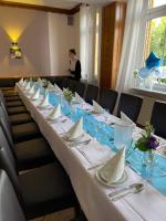 a long table in a room with a woman in the background at Hotel-Restaurant zur Post in Wabern