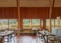 a dining room with tables and chairs and windows at Explora Valle Sagrado in Urubamba