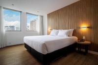 a hotel room with a large bed and two windows at Sooz Hotel Collection in Sao Paulo