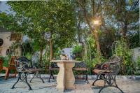 a table and chairs in a patio with trees at Hotel Ambavgarh Palace in Udaipur