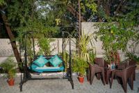 a bench with blue pillows and a table and chairs at Hotel Ambavgarh Palace in Udaipur