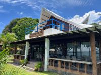 una casa rodeada de un porche con sillas en Infinity Diving Resort and Residences, en Dauin