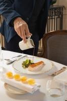 una persona vertiendo comida en un plato de comida en Chateau d'Audrieu, en Audrieu