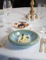 una mesa blanca con un plato de comida. en Chateau d'Audrieu, en Audrieu