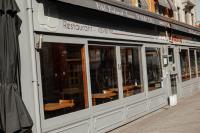 Un escaparate de un restaurante con mesas en él. en Hotel Le Limbourg, en Rochefort