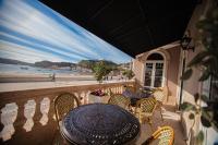 Una mesa y sillas en un balcón con vista a la playa. en Storytellers Palace, en São Martinho do Porto