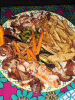 une assiette de nourriture avec de la viande et des frites dans l'établissement Villa Adelina Zanzibar, à Zanzibar City