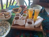 - une table avec un plateau de nourriture et 2 verres de bière dans l'établissement Villa Adelina Zanzibar, à Zanzibar City