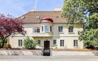 a large white house with a red roof at Köpmansgården Bed &amp; Breakfast in Vellinge