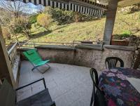 a green chair and a table on a patio at Gîte Elisa in Vals-les-Bains