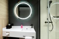 a bathroom with a white sink and a mirror at Moxy The Hague in The Hague