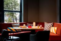 a room with a table and a couch at Moxy The Hague in The Hague
