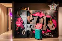 a wall covered in graffiti with a suitcase in a room at Moxy The Hague in The Hague