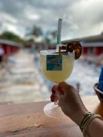 a person holding up a drink in a glass at Hotel Pousada Villa Itália Olímpia in Olímpia