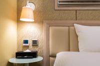 a bedroom with a bed and a lamp and a night stand at The Cloud Hotel in Kaohsiung