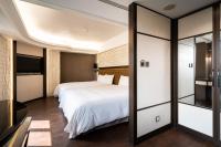 a hotel room with two beds and a tv at The Cloud Hotel in Kaohsiung