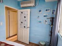 a bedroom with a blue wall with a fan and a door at MB Hotel in Kaohsiung