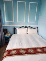 a bedroom with a large bed with blue walls at MB Hotel in Kaohsiung