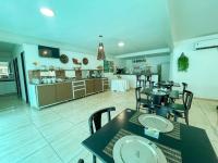 una sala da pranzo con tavoli e sedie e una cucina di HOTEL CAJUÍNA BEACH a Parnaíba