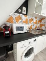 a kitchen with a microwave and a washing machine at L&#39;ENSOLEILLÉ - Classé 2 étoiles - Nay centre - Appartement in Nay