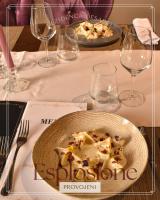 un plato de comida en una mesa con copas de vino en Hotel Rezidenca Desaret, en Berat