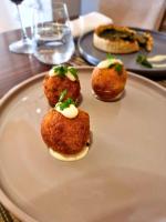Un plato con cuatro alimentos sobre una mesa. en Hotel Rezidenca Desaret, en Berat