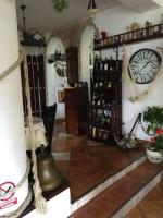 Una habitación con un reloj en la pared y un estante con botellas de vino. en Ancora, en Predeal