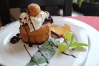 Un plato blanco con un pastel y fruta encima. en Ancora, en Predeal