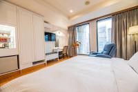 a bedroom with a large white bed and a desk at Wenpin Hotel - Pier 2 in Kaohsiung