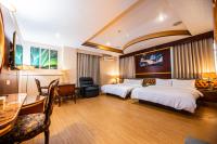 a hotel room with two beds and a desk at Wenpin Hotel - Pier 2 in Kaohsiung