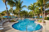 einen Pool mit Stühlen und Palmen in einem Resort in der Unterkunft Cheeca Lodge &amp; Spa in Islamorada