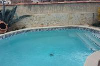 una piscina de agua azul y una pared de piedra en Maison avec jacuzzi, en Istres