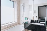 a bathroom with a tub and a sink and a mirror at Courtyard by Marriott Stockholm Kungsholmen in Stockholm