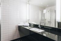 a bathroom with a sink and a mirror at Courtyard by Marriott Stockholm Kungsholmen in Stockholm
