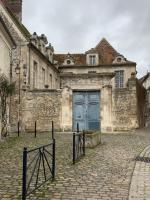 an old stone building with a blue door at La Maison Saint Joseph in Crépy-en-Valois