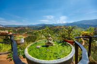 Una estatua sentada en un jardín con vistas. en Midori Heritage Coffee Farm, en Da Lat