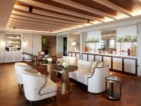a living room with a couch and chairs and a bar at Jumeirah Mina Al Salam Dubai in Dubai