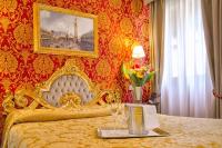 a bedroom with a gold bed with a table with flowers at Residenza Goldoni in Venice