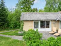 a brick cottage with two chairs and a patio at Holiday Home Bjarne - 1-2km from the sea in Sealand by Interhome in Tisvildeleje