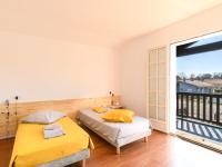 two beds in a room with a large window at Holiday Home Les Chênes by Interhome in Lit-et-Mixe