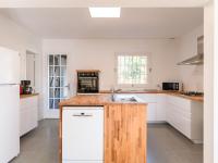 a kitchen with white cabinets and a wooden counter top at Holiday Home Les Chênes by Interhome in Lit-et-Mixe