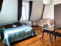 a bedroom with a bed and a table and a couch at Demeure des Dentelles in Le Puy-en-Velay